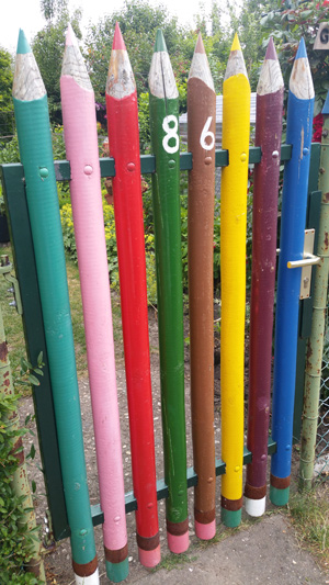 Zaun aus bunten riesigen Buntstiften